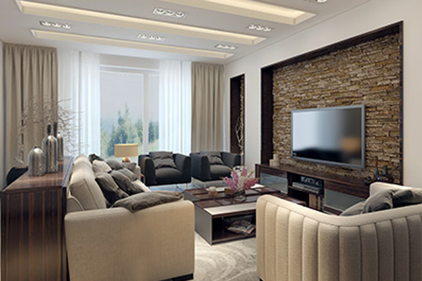 Modern living room with neutral tones, featuring a stone accent wall with a flat-screen TV, beige sofas, a sleek coffee table, and large curtained window.