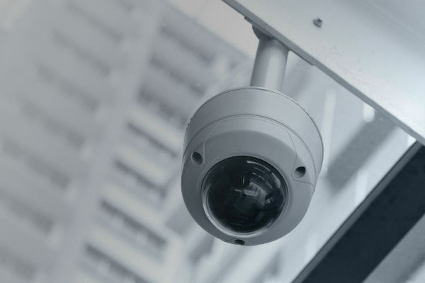 Close up of a rounded surveillance camera against a blurred background